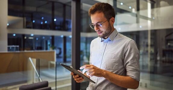 Man in office, working on tablet in the office Man in office, working on tablet in the office