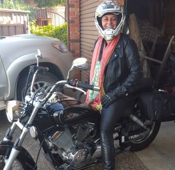 woman wearing a helmet and sitting on a motorbike