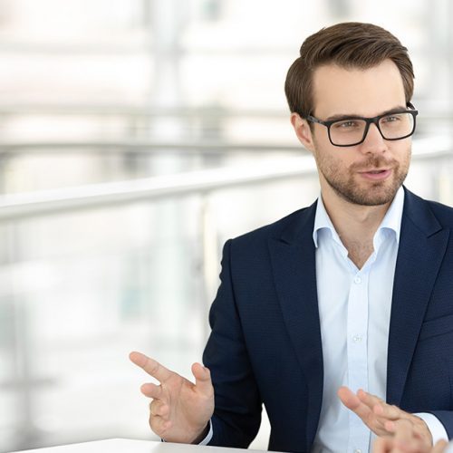 Smiling male office worker talking with female colleague