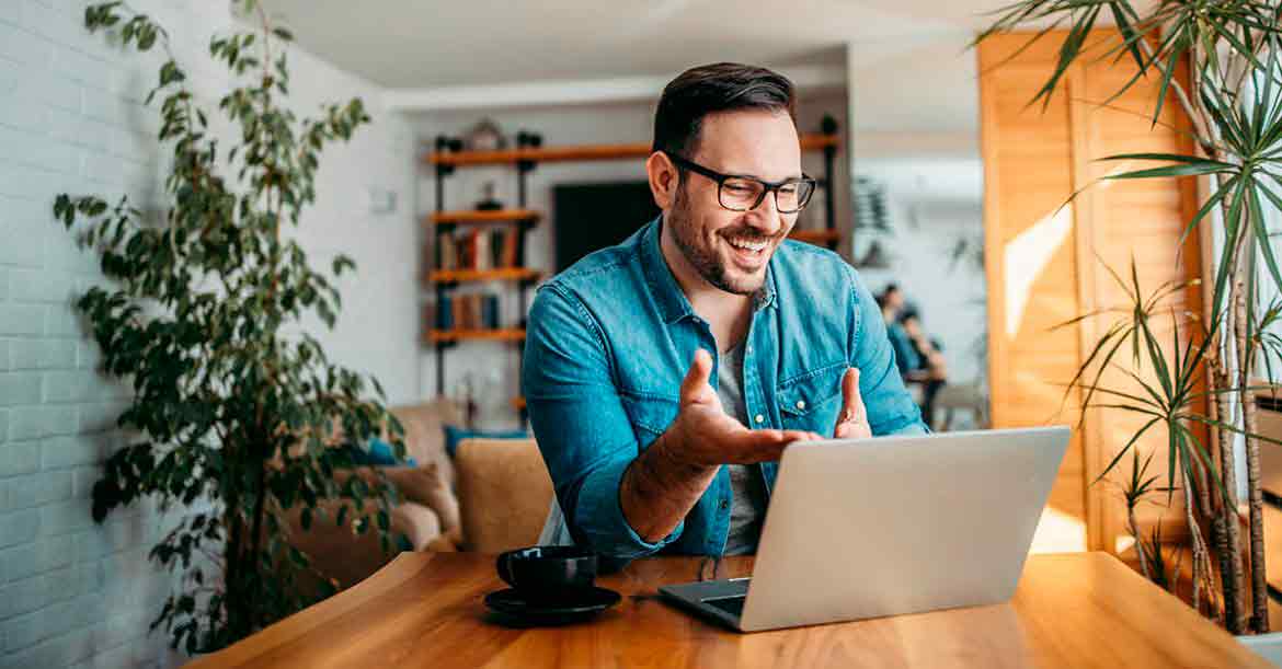 Portrait of a cheerful man having video call on laptop computer