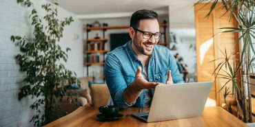 Portrait of a cheerful man having video call on laptop computer