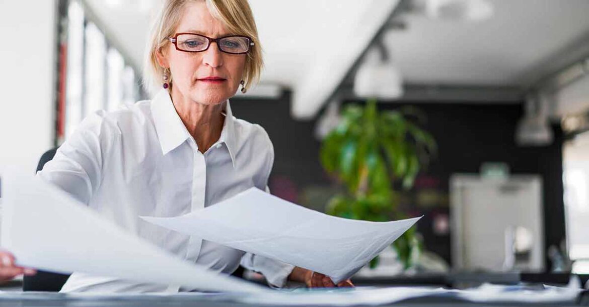 Businesswoman examining documents at desk