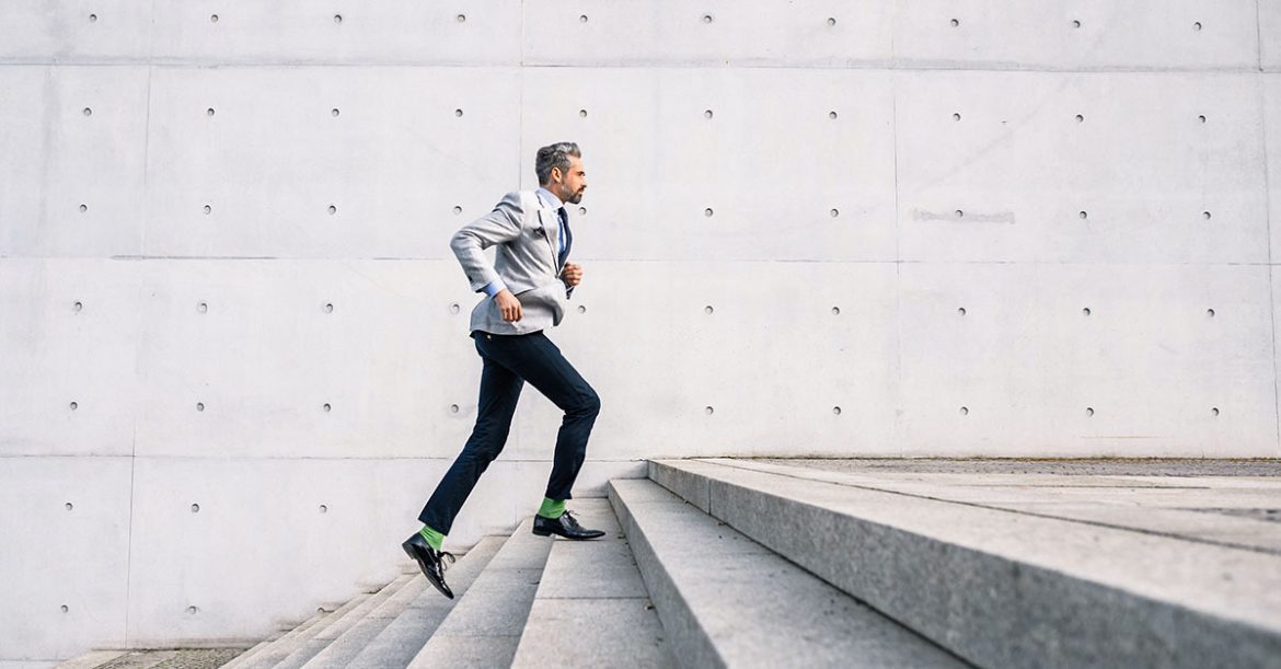 Business man running up the stairs