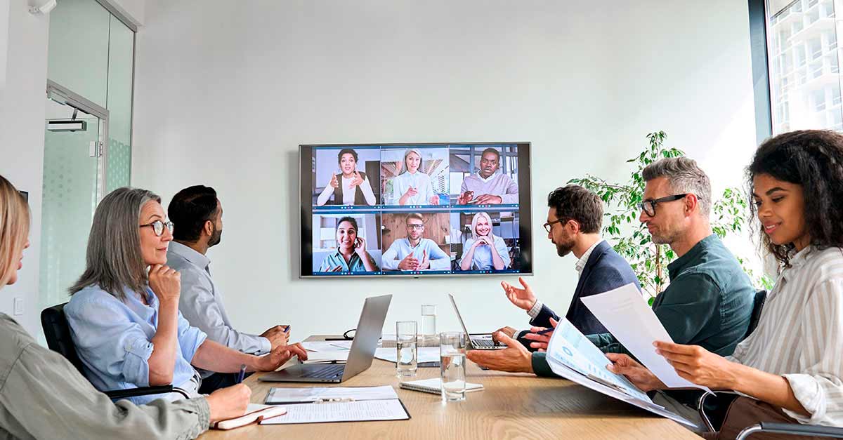 Diverse employees on online conference video call on tv screen in meeting room