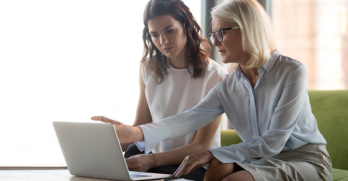 Serious middle aged executive manager explaining colleague online work