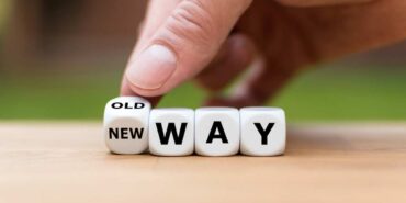 Hand is turning a dice and changes the expression “old way” to “new way”