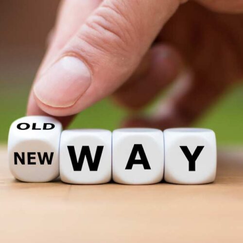 Hand is turning a dice and changes the expression “old way” to “new way”