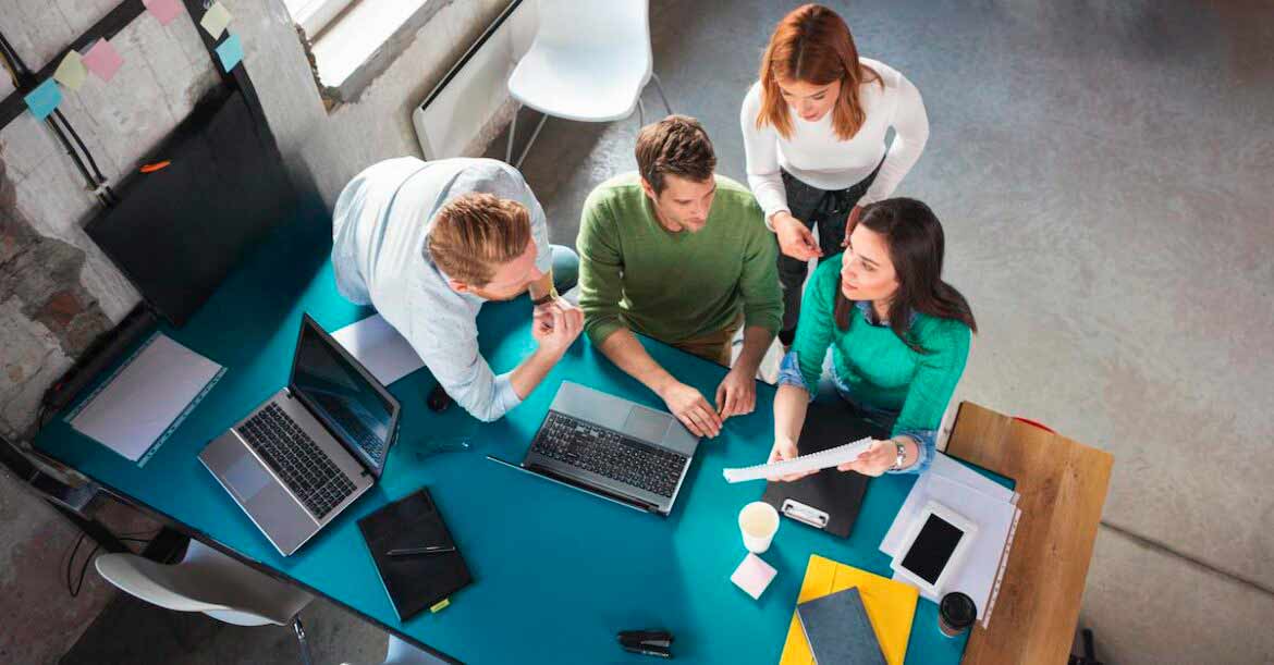 Group of professionals around a table taking guidance from an analyst