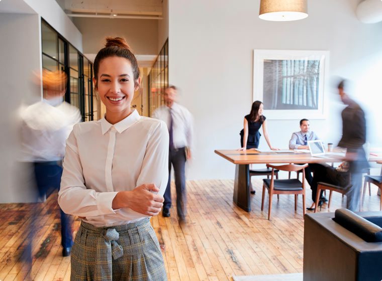 Portrait of young white woman in a busy modern workplace